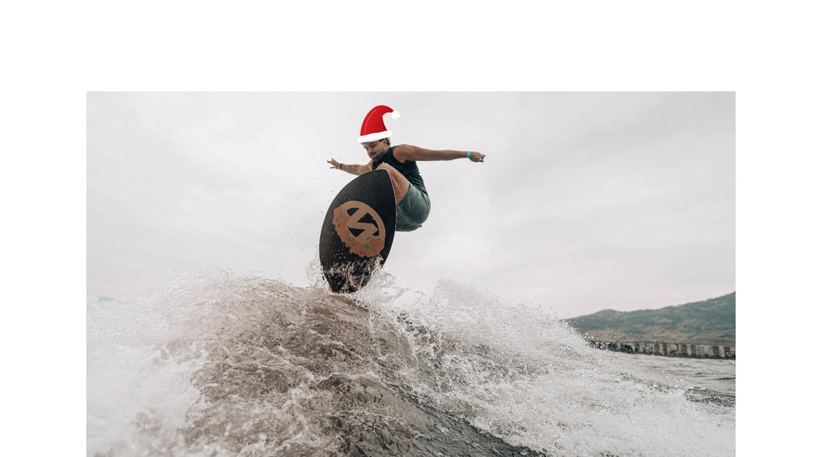 Kanuk rider on a wake skim board wearing a Santa hat